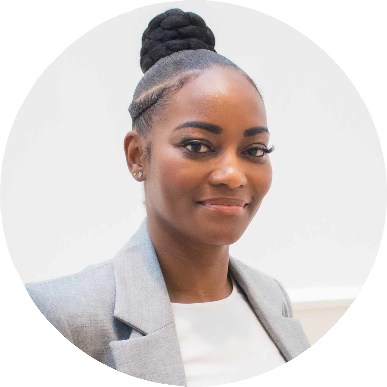 Picture of Jane Echteld. A beautiful black woman with black hair in a updo, wearing a grey jacket with a white top.